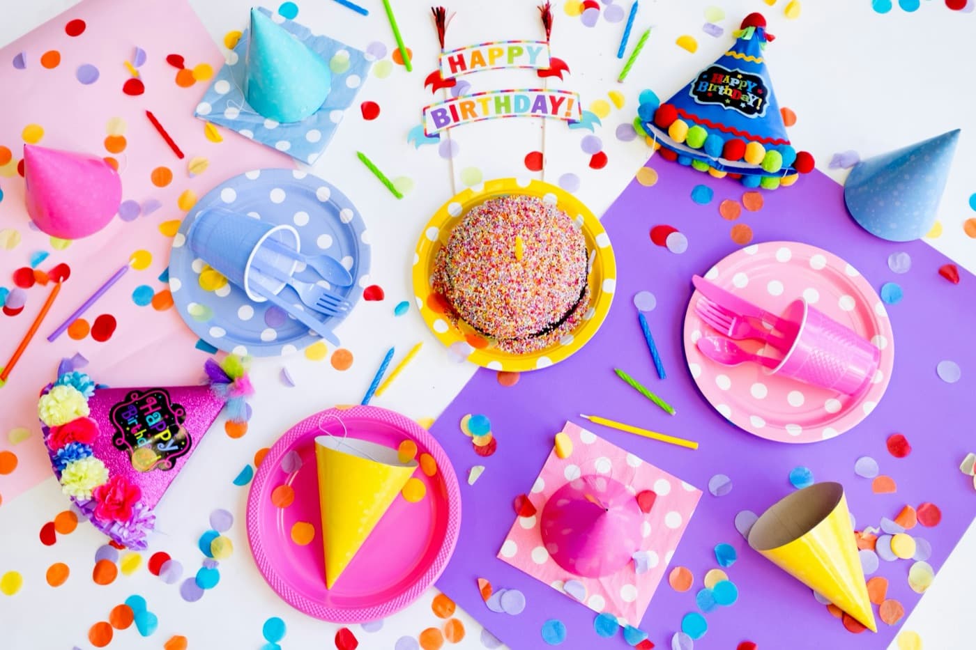 Mesa de fiesta con gorritos, platos y confeti
